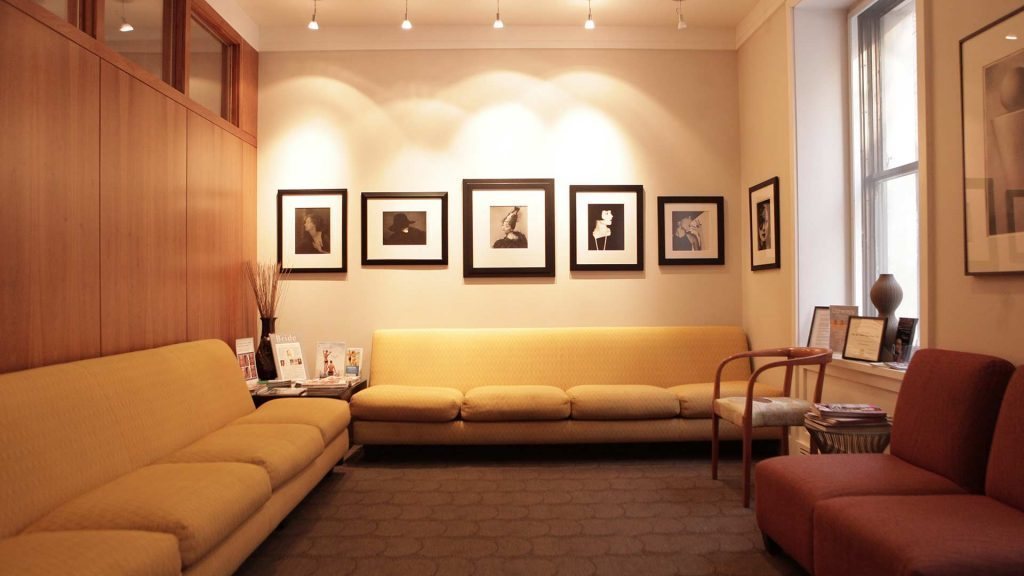 Cozy living room with yellow sofas and framed pictures on the wall.